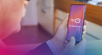 Person hält Handy in der Hand, auf dem die ID Austria angezeigt wird. 