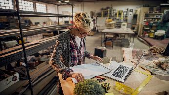 Frau in einer Werkstatt mit Laptop  ©  Unsplash+ 