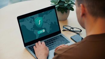 Mann sitzt vor Laptop auf dem ein Bild mit der Aufschrift VPN zu sehen ist © Dan Nelson  - Unsplash 