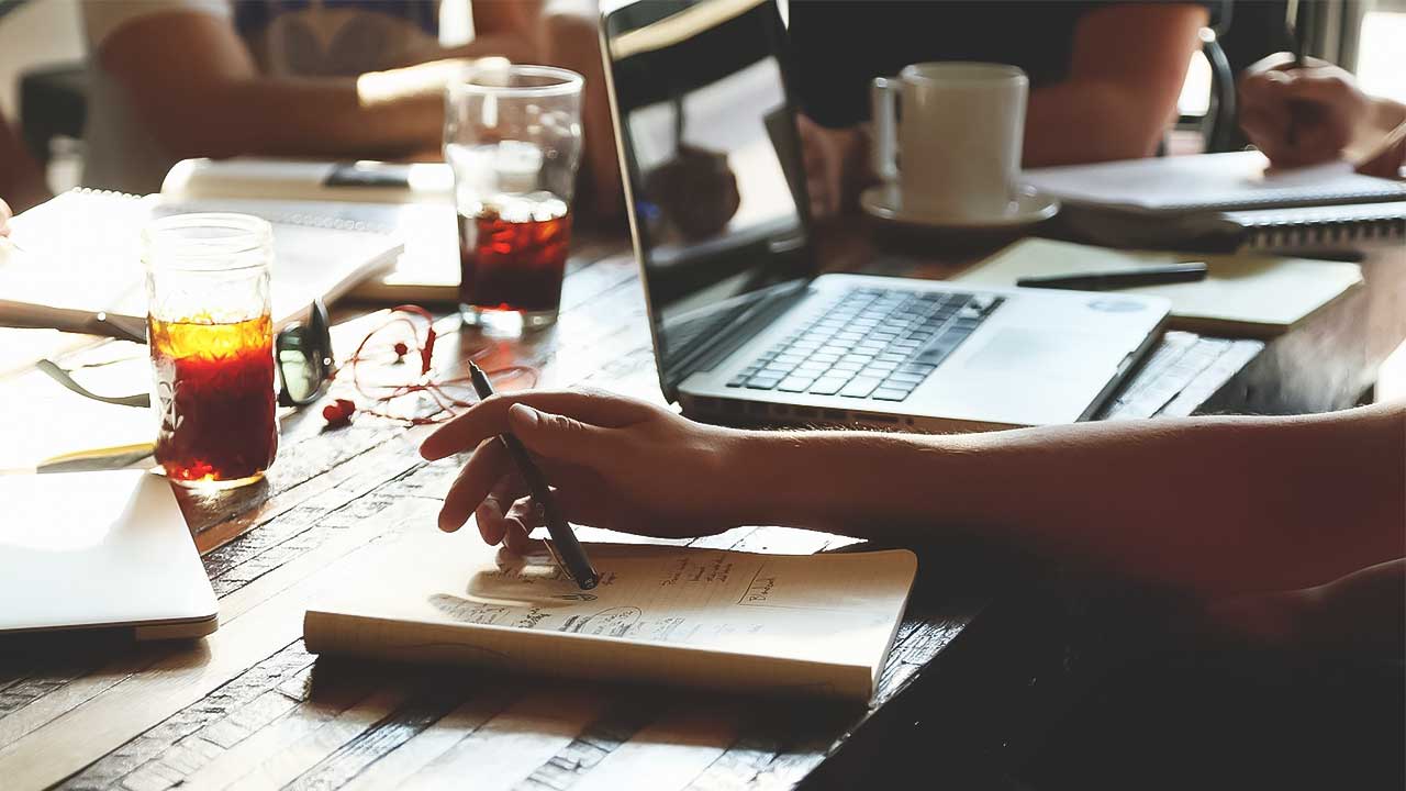 Vollgeräumter Tisch mit Laptop und Hand mit Stift © StartupStockPhotos  - pixabay.com 