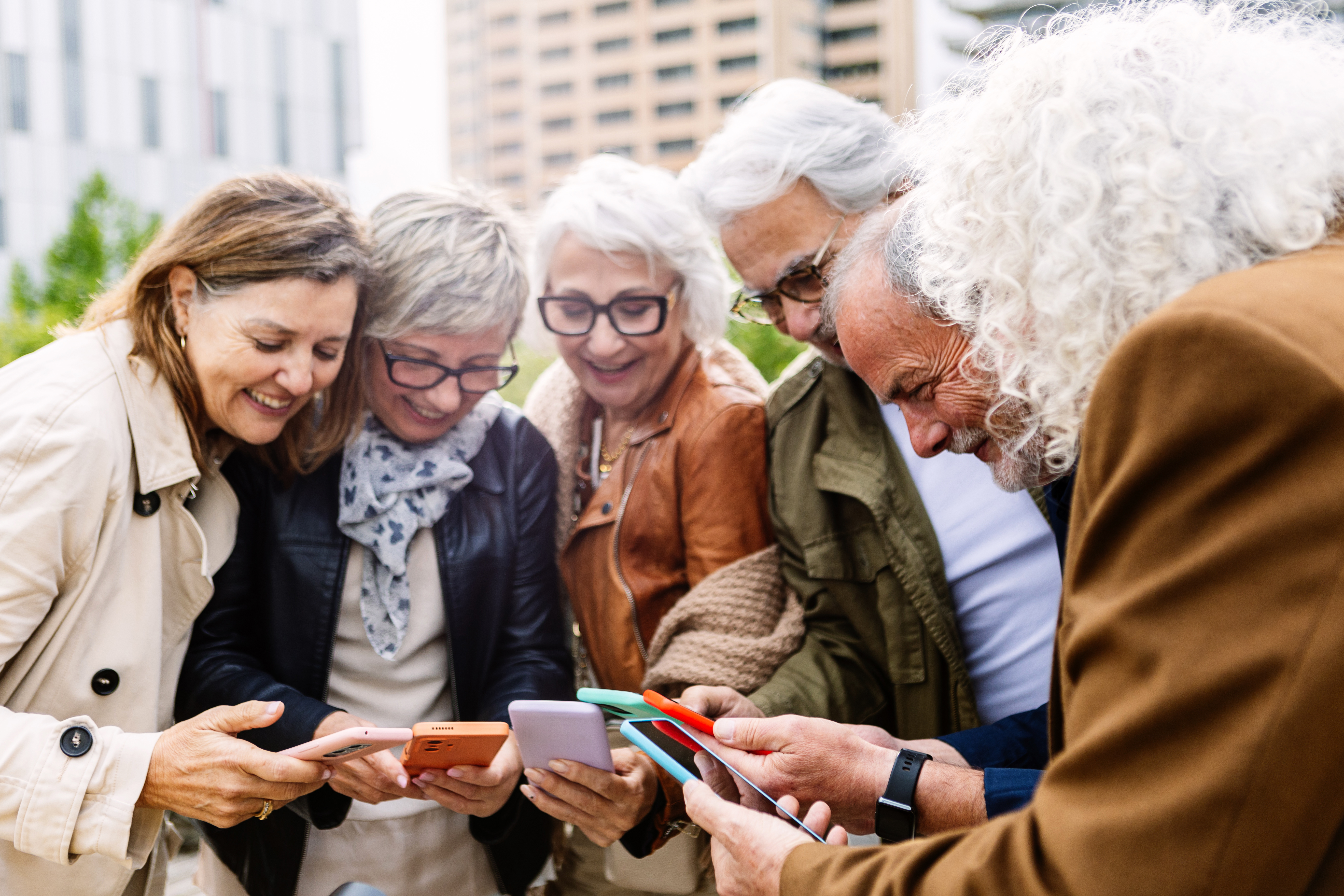 Eine Seniorengruppe nutzt Mobiltelefone und steht im Freien im Kreis.  © Xavier Lorenzo  - 868803017 