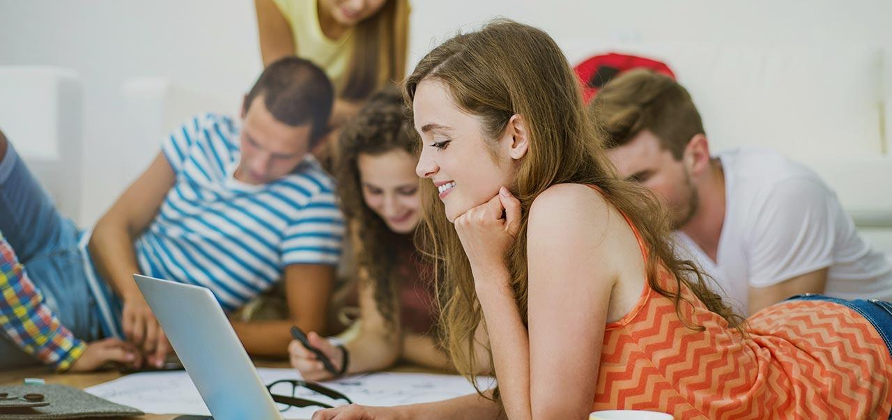 Gruppe von Personen liegt auf dem Boden und arbeitet gemeinsam mit Laptops und Schreibzeug an einem Projekt ©  Unsplash+ 