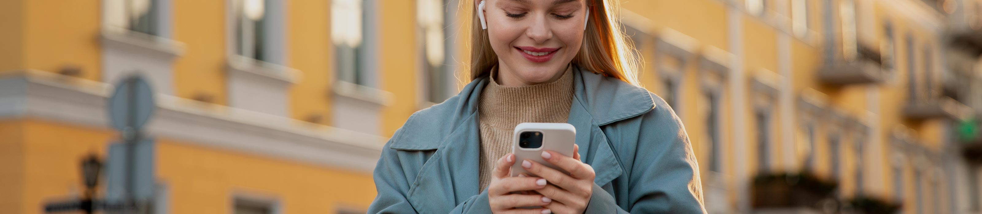 Junge Frau hält lächelnd Smartphone in der Hand ©  freepik.com 