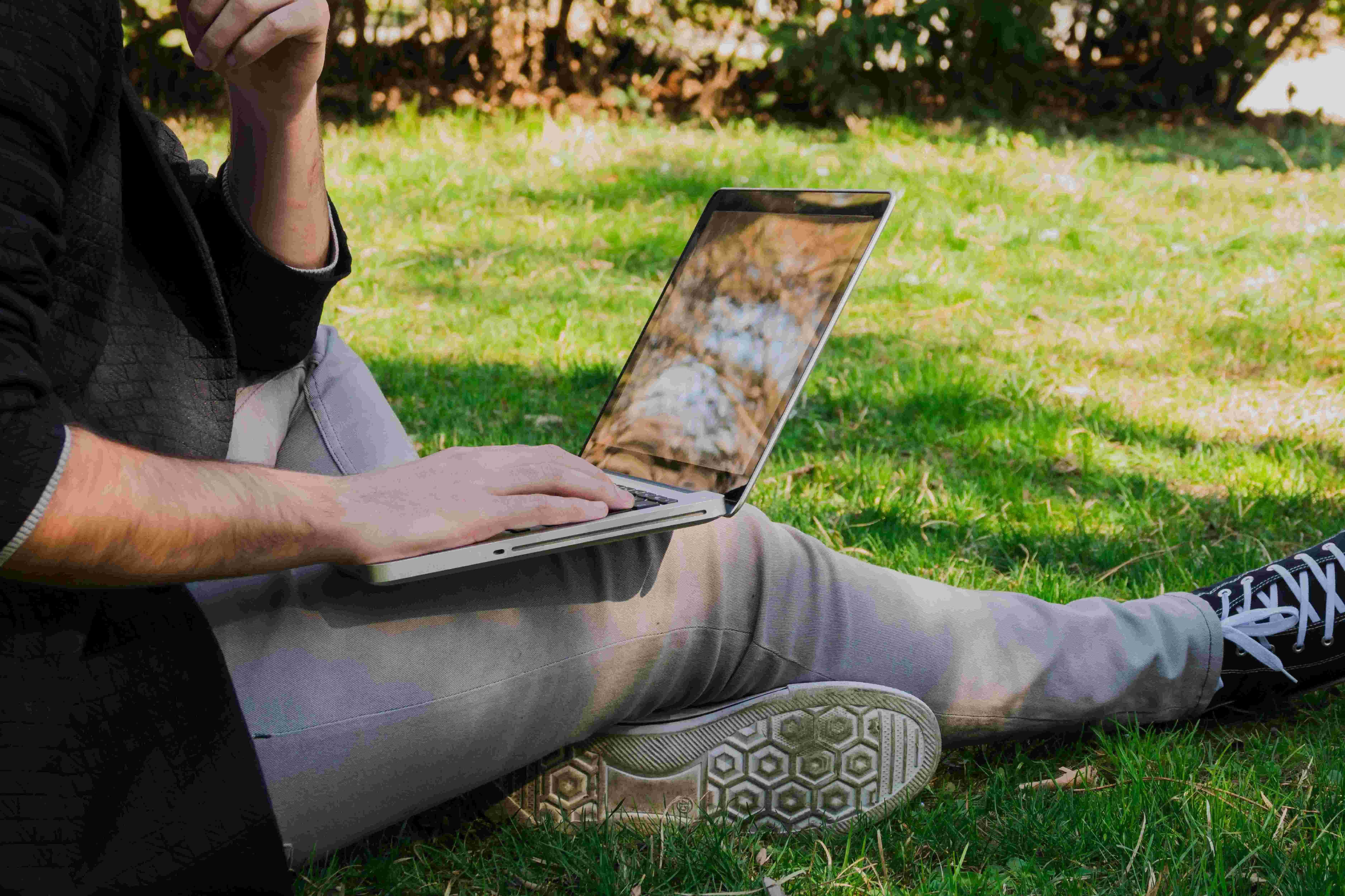 Person sitzt mit Laptop in Wiese ©  freepik.com 
