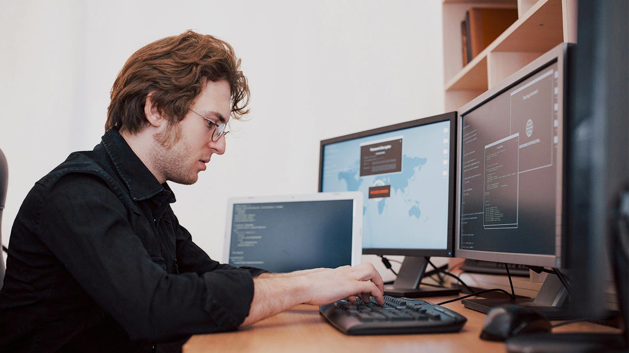 Mann sitzt vor Computer und tippt etwas auf der Tastatur ©  Unsplash+ 