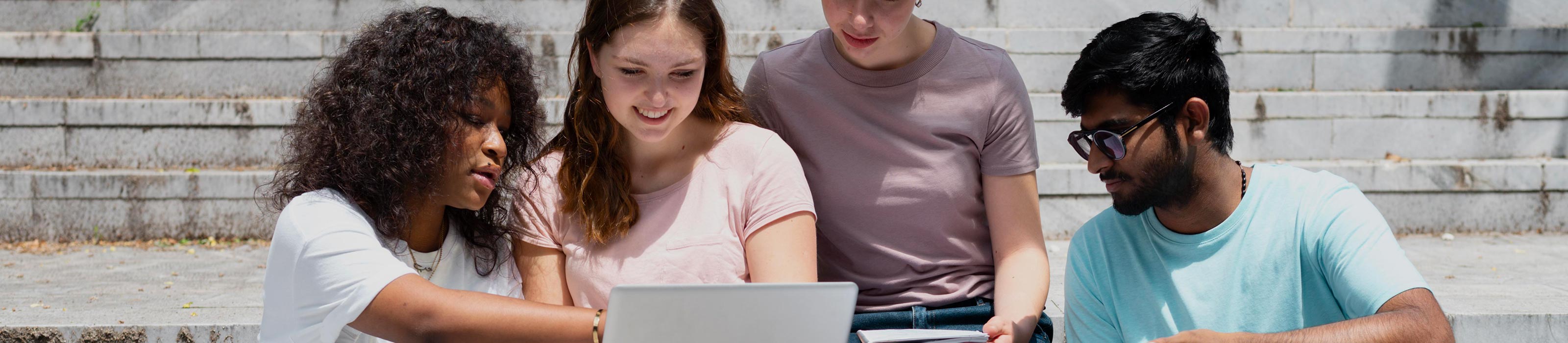 Vier teeanger sitzen gemeinsam vor einem Laptop © freepik.com